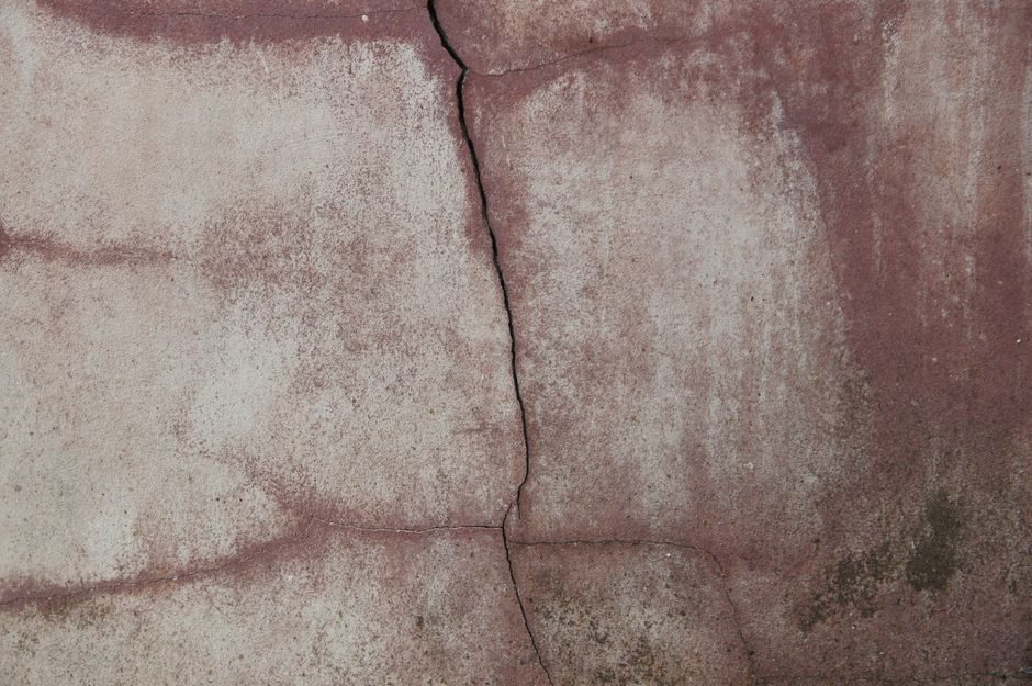 Close-up of an aged concrete wall with prominent crack, depicting texture and wear.